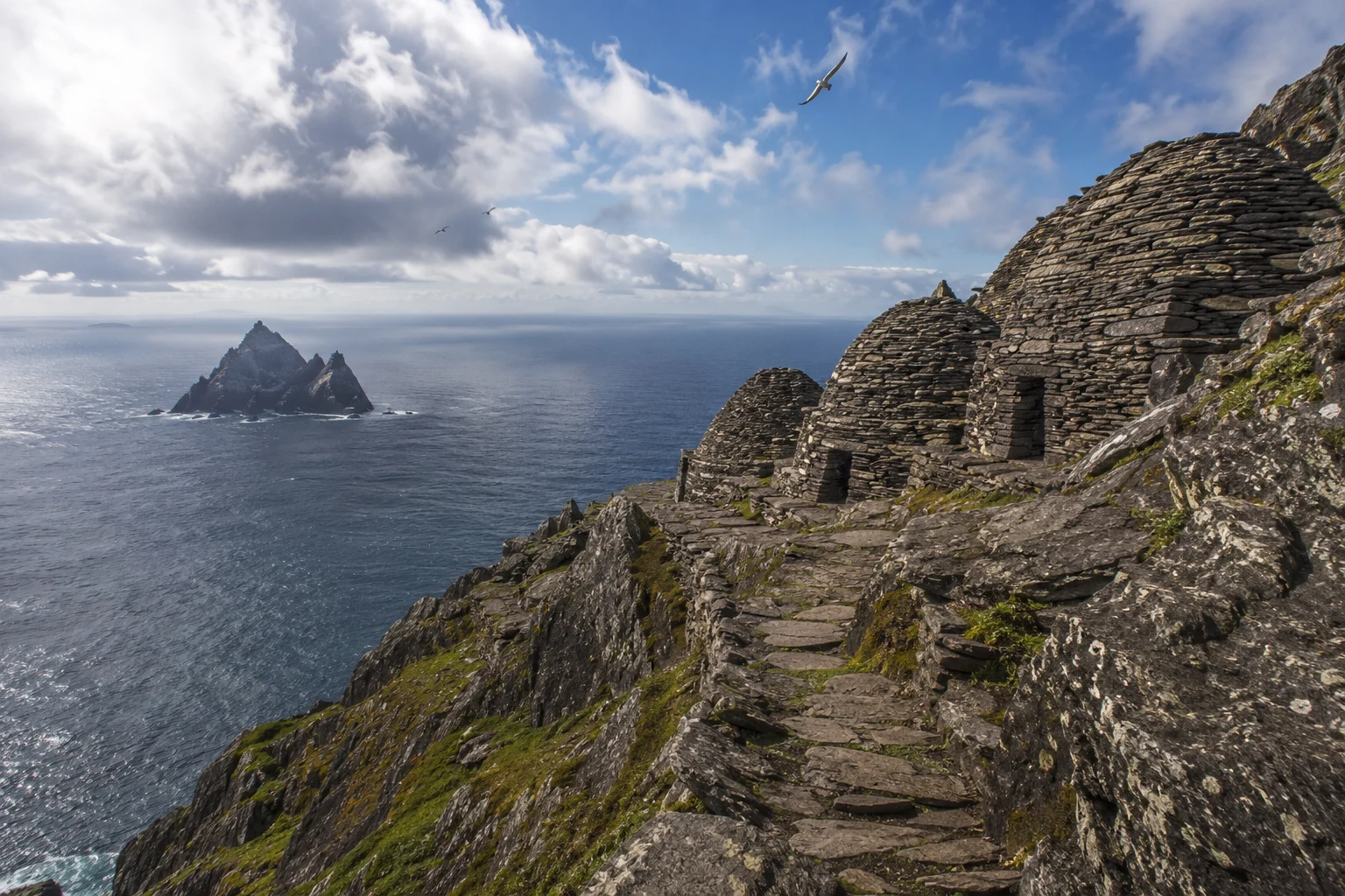 Stone beehive monastic huts on the steep cliffs of Skellig Michael, Ireland, overlooking the Atlantic